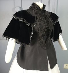 An opulent Victorian antique jacket dating to the 1880s ( the back definitely seems to be cut to accommodate a bustle, so i'm thinking 1880s ) - a nice gothic piece and an interesting alternative to the usual bustle mantle. Made in black ribbed silk faille, the torso fitted to a curvaceous hourglass, swelling at the back for a bustle and fastening with hooks at centre front. This part is sleeveless, the armholes finished with silk binding. The front is decorated with vertical black lace frills, Baroque Victorian Dress Costume, Vintage Victorian Dress For Fall Costume Party, Victorian Dress With Ruffles For Fall, Fall Victorian Dress With Ruffles, Victorian Historical Outerwear For Costumes, Victorian Style Historical Costume Outerwear, Victorian Outerwear With Historical Design For Costume, Victorian Dress For Vintage Events With Historical Design, Victorian Dress With Historical Design For Evening