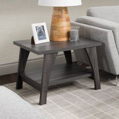 a living room with a gray couch and a wooden table on the floor next to a chair