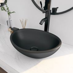 a black bowl sink sitting on top of a counter next to a wall mounted mirror