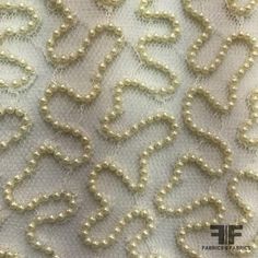 white pearls are laid out on the fabric