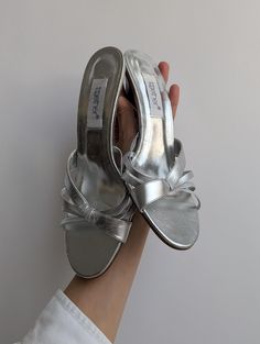 These stylish vintage silver leather straps sandals by Together feature sleek wooden heels, offering both comfort and trend-worthy appeal. In good condition, these sandals are the perfect blend of elegance and everyday wearability, making them a versatile choice for any wardrobe.   Era: 1990s - early 2000s Measurements: 25 x 8.5  inches, 8 cm heel Silver Mules For Spring, Silver Open Toe Mules With Padded Heel, Silver Mules With Wrapped Heel For Formal Occasions, Silver Open Toe Mules With Removable Insole, Vintage Formal Sandals With Removable Insole, Vintage Sandals With Padded Heel For Summer, Classic Silver Sandals For Summer, Silver Mules With Padded Heel For Formal Wear, Silver Mules With Padded Heel For Formal Occasions