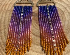 two pairs of beaded earrings on top of a wooden table