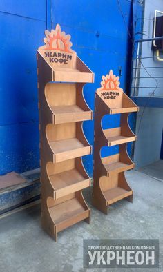 two wooden bookshelves sitting next to each other in front of a blue wall