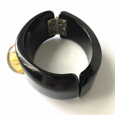 "Item: This is a fabulous black bakelite clamper bangle bracelet with a reverse carved apple juice flower cabochon mounted in the center. It's in excellent condition, has been tested and guaranteed vintage bakelite. Be sure to check our other listings for lots more bakelite jewelry! Measurements: 1 1/4\" wide in front - 2 1/4\" inner oval diameter, 6 3/8\" inner circumference. Condition: 9.5 - Excellent Shipping: US buyers pay $14.95 for Fully Insured USPS Priority Mail with Tracking. Internatio Vintage Bakelite Bangle Jewelry, Vintage Bakelite Bangle, Vintage Lucite Bangle Bracelet, Retro Bakelite Jewelry, Retro Round Bakelite Jewelry, Elegant Bakelite Bracelet Jewelry, Elegant Bakelite Bracelet, Vintage Bakelite Bracelet, Vintage Black Bangle Cuff Bracelet