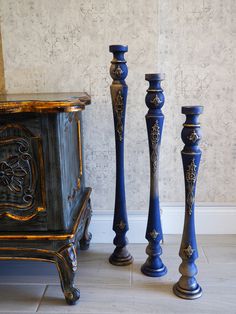 three tall blue vases sitting next to each other on a tile floor in front of a wall