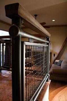 a living room filled with furniture and a metal fence on top of a hard wood floor