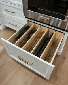 an open drawer in the middle of a kitchen