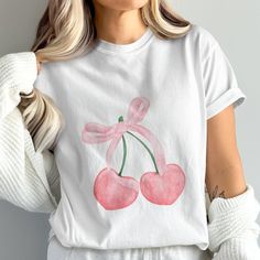 This cute cherry bow T-shirt features an adorable cherry design with a pink bow. Perfect for adding a touch of kawaii and aesthetic style to your wardrobe. Ideal for casual wear, this trendy cherry graphic tee is great for summer outings, picnics, or a day at the park. Embrace the sweetness with this lovely cherry top and make your outfit pop. Product Features: Comfort Colors 1717 adult tee. Fabrication: Medium fabric (6.1 oz/yd² (206.8 g/m. Garment-dyed fabric. 100% ring-spun cotton Fit: Relaxed fit Sizing: Unisex Sizing Label: Sewn-in twill label Kawaii Cherry, Coquette Cherry, Cherry Graphic, Fruit Graphic, Cherry Shirt, Bachelorette Tees, Cherry Design, Style Kawaii, Aesthetic Style