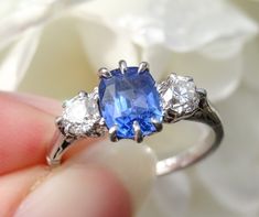 a blue and white ring with three diamonds