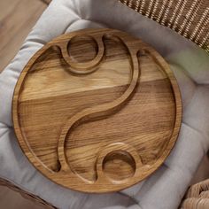 a wooden plate sitting on top of a white cushion next to a wicker basket