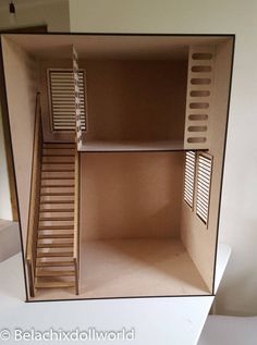 the inside of a cardboard dollhouse with wooden stairs and shutters on each side