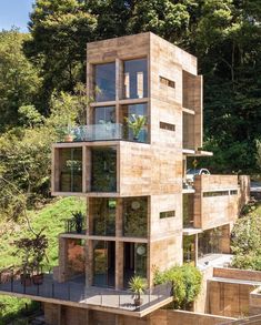 an unusual house in the woods with lots of windows and balconies on it