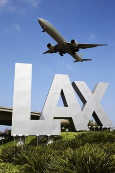 an airplane is flying over the lax sign