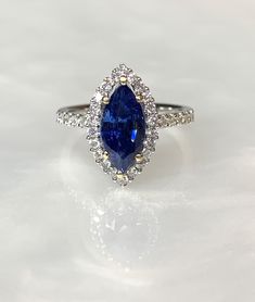 A queenly and enchanting blue sapphire ring featuring a marquise shaped center stone weighing 3.00 carats surrounded by 0.58 carats of sparkling white diamonds set in solid 18k white gold. Get this luxurious one-of-a-kind piece now, as it will not be produced again. Blue Sapphire Diamond Ring, Blue Sapphire Ring, Blue Sapphire Diamond, Sapphire Diamond Ring, Halo Diamond Ring, Blue Sapphire Rings, Halo Rings, Marquise Cut, Sapphire Diamond