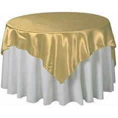 a gold and white table cloth on top of a round table with a silver skirt