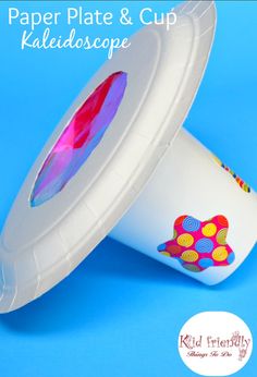 a white cup with colorful designs on it sitting next to a blue background and the lid is open