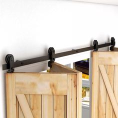 two wooden doors open to reveal a refrigerator