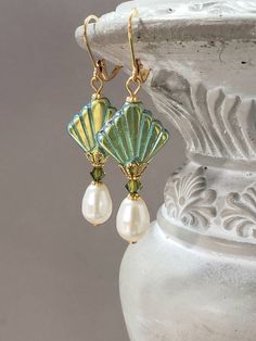 I created these Art Deco inspired earrings with some of my favorite jewelry components - Czech glass beads, Swarovski crystals, and Swarovski pearls. This is a classic Deco design; perfect for a 1920s style wedding or party. The Czech beads are shaped like fans; one of the most popular design motifs during the Art Deco period. Each Czech glass bead has a Aurora Borealis finish on one side and a solid peridot green color on the opposite side. (SEE PHOTO 2) Beautiful Swarovski crystals and pearls Nickel-free Czech Glass Earrings For Wedding, Nickel-free Czech Glass Wedding Earrings, Elegant Czech Glass Earrings For Pierced Ears, Elegant Czech Glass Earrings, Elegant Bead Caps Drop Earrings Jewelry, Elegant Drop Earrings Jewelry With Bead Caps, Elegant Dangle Earrings With Bead Caps, Elegant Czech Glass Earrings For Jewelry Making, Elegant Drop Earrings With Bead Caps