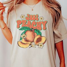 summer time graphic shirt | peachy tee | botanical shirt | fruit drawing tshirt | fresh peaches shirt |  This Bella T-shirt is light-weight with just the right amount of stretch. Perfect for wearing on its own or layering with a jacket or cardigan - this Tee is comfortable, soft, and durable. * 100% combed and ring-spun cotton * Fabric weight: 4.2 oz (142 g/m2) * Pre-shrunk fabric * Side-seamed construction * Shoulder-to-shoulder taping * We do not accept returns or exchanges. However, if you experience an issue with them item received, please message the shop Woah there! It looks like you've gone a little too far - don't like this tshirt? No problem, we won't take it personally 😉 You can check out some of our other great designs back at our shop here: https://www.etsy.com/shop/TheSimplyS Fruit Tshirt Design, Peach Short Sleeve T-shirt For Summer, Casual Peach T-shirt With Graphic Print, Trendy Peach T-shirt With Letter Print, Spring Tops With Fruit Print, Trendy Peach Short Sleeve T-shirt, Peach Short Sleeve Summer Tops, Vintage Summer Top With Fruit Print, Vintage Fruit Print Top For Summer