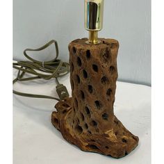 a lamp that is made out of wood and has holes in the bark on it