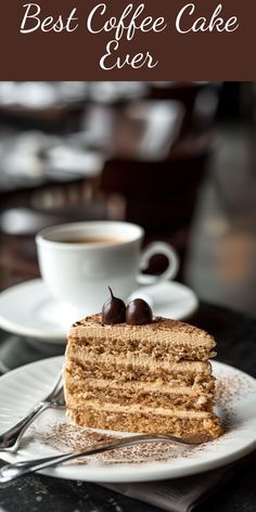 a piece of cake sitting on top of a white plate next to a cup of coffee