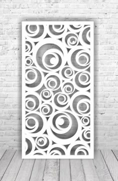 a black and white poster with circles on it in front of a brick wall,