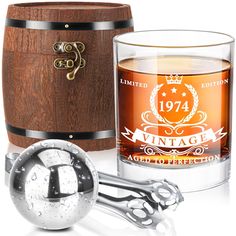 an old fashioned whiskey glass next to a wooden barrel with a corkscrew handle