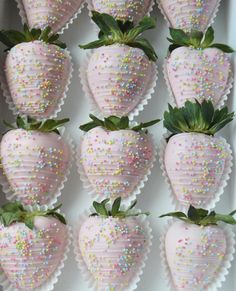 a box filled with lots of pink strawberries covered in sprinkles on top of each other