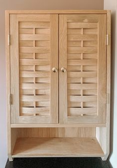 a wooden cabinet with shutters on the doors