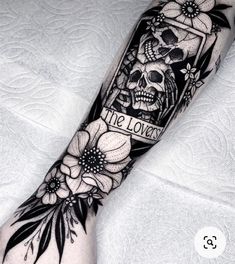 a person with a tattoo on their arm that has flowers and a skull in it