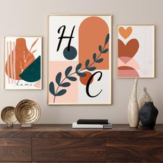 three framed art prints on a wall above a dresser with vases and other items