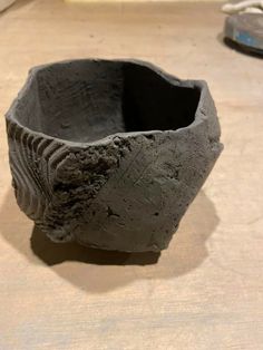 a clay bowl sitting on top of a wooden table