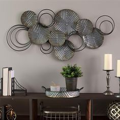 a table with a potted plant and some metal circles on the wall above it