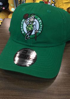 This Boston Celtics Green Adjustable Hat features a team logo embroidered on the front. Team logo embroidered on the front, Cloth Strap Closure to dial in the perfect fit, Relaxed, unstructured fit, Pre-curved bill, 100% cotton construction, New Era Flag logo on side, Dad hat, 100% Cotton, Washable, Imported Casual Team-colored Baseball Cap With Logo, Cotton Hat With Team Logo For Sports Events, Cotton Sports Hat With Team Logo, Sporty Cotton Hats For Fan Merchandise, Team-colored Cotton Hat With Embroidered Logo, Casual Game Day Hat With Logo Patch, Casual Hats With Logo Patch For Game Day, Sports Fan Cotton Hat For Fan Merchandise, Sports Fan Hat In Cotton For Fan Merchandise