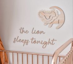 the lion sleeps tonight sign is mounted on the wall above a crib in a baby's room