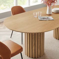 a round wooden table with four chairs around it and plates on the table next to it