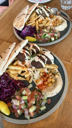 two plates filled with different types of food on top of a wooden table next to each other