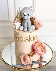 an image of a cat cake with flowers on the top and gold trimmings