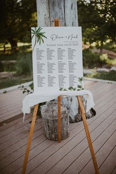 a wooden easel with a sign on it that says guests to the wedding ceremony