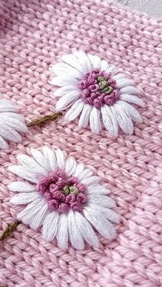 two white flowers on pink knitted blanket