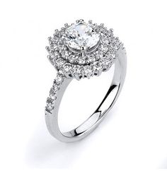 a white gold ring with an oval diamond center surrounded by small round brilliant cut diamonds