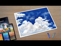 there is an image of clouds and crayons on the table next to it