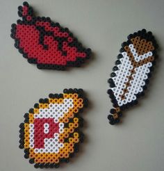 three pieces of perler bead art on a table