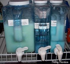 three water jugs are stacked on top of each other in the refrigerator, and one is filled with blue liquid