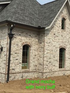 a brick building with two windows and a black light on the roof is under construction