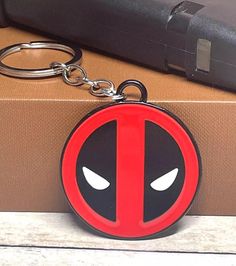 a deadpool keychain sitting on top of a suitcase