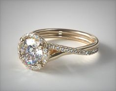 a white gold ring with an oval cut diamond surrounded by pave - set diamonds