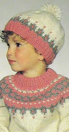 a young child wearing a knitted hat and sweater