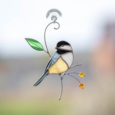 a stained glass bird sitting on a branch