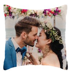 a couple kissing each other with flowers on their head and holding wine glasses in front of them